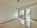 Bright and spacious main living area with large windows and white tile flooring