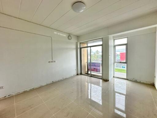 Bright and spacious main living area with large windows and white tile flooring