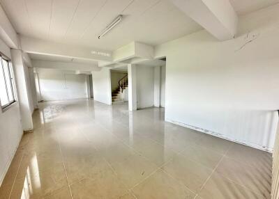 Spacious main living area with tiled floor and staircase