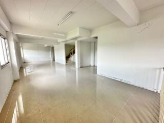 Spacious main living area with tiled floor and staircase