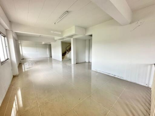 Spacious main living area with tiled floor and staircase