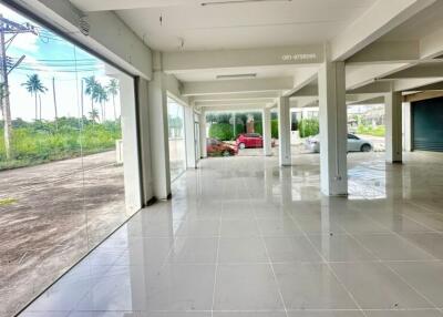 spacious commercial area with large windows and tiled flooring