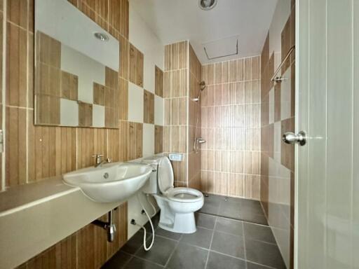 Modern bathroom with large tiles, wall-mounted sink, and toilet