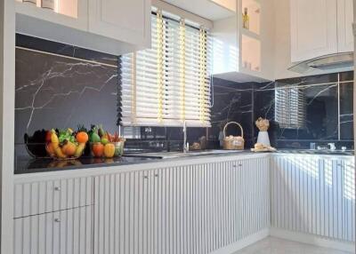 Modern kitchen with white cabinets and black marble backsplash