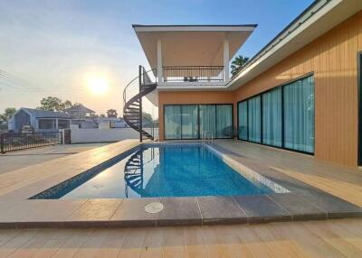 Outdoor swimming pool with modern house in the background