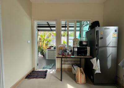 Simple kitchen area with refrigerator and small table