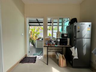 Simple kitchen area with refrigerator and small table