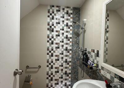 Modern bathroom with mosaic tiles, walk-in shower, and a vanity mirror