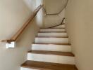 Well-lit interior staircase with wooden steps and handrails