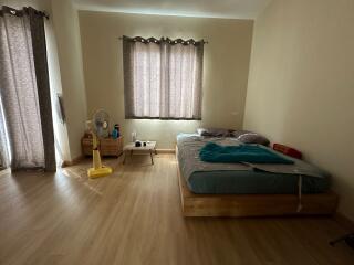 Spacious bedroom with wooden flooring and a large bed