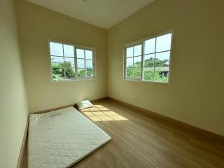 Empty bedroom with two windows and a mattress on the floor