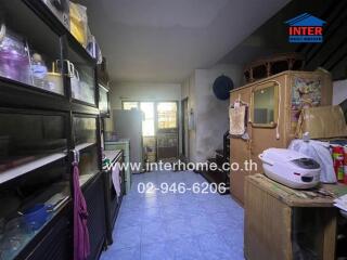 A modest kitchen with storage cabinets, appliances, and a tiled floor