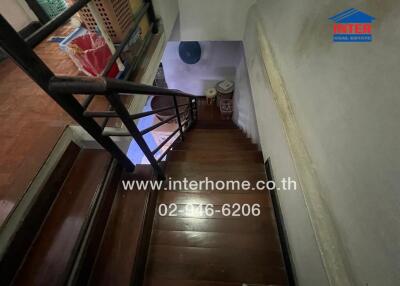 Wooden staircase with railing and storage space under the stairs