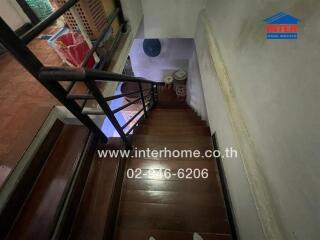 Wooden staircase with railing and storage space under the stairs