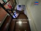 Wooden staircase with railing and storage space under the stairs