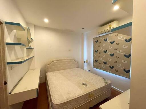 Bedroom with double bed and wall shelves