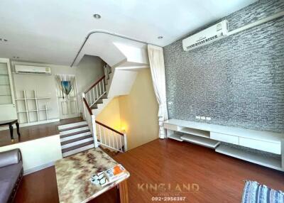 Spacious living room with modern staircase and air conditioning