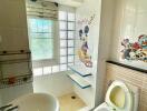 Bathroom with cartoon-themed decor, featuring a sink, toilet, and shower area