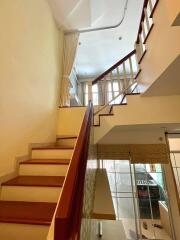 Staircase with wooden railing leading to second floor