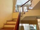 Staircase with wooden railing leading to second floor