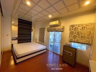 Spacious bedroom with bed, air conditioner, and safe