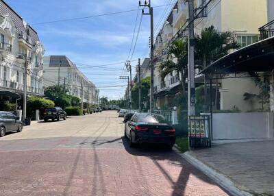 Street view of residential buildings with parked cars