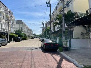 Street view of residential buildings with parked cars