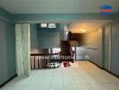 Main living area with tile flooring and wooden staircase