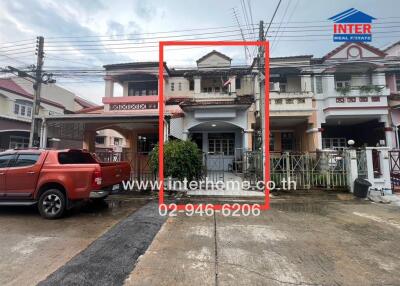 Front view of residential townhouse with attached garage and driveway