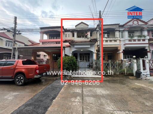 Front view of residential townhouse with attached garage and driveway