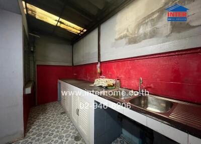 A kitchen area with countertops, a sink, and storage cabinets