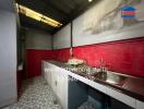 A kitchen area with countertops, a sink, and storage cabinets