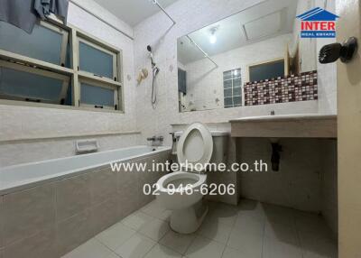 A bathroom with a bathtub, toilet, sink, and wall mirror