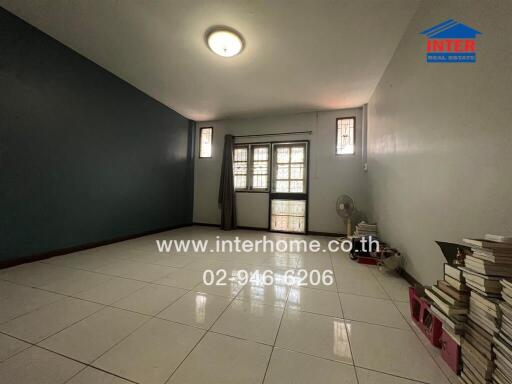 Spacious living room with tiled flooring and large window