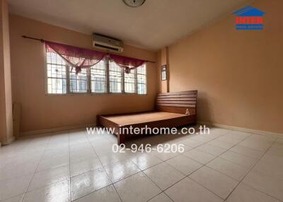 Spacious bedroom with tiled flooring and a large window