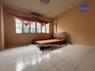 Spacious bedroom with tiled flooring and a large window