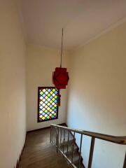 Staircase with colorful window and hanging lamp