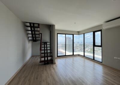 Spacious living area with large windows and staircase