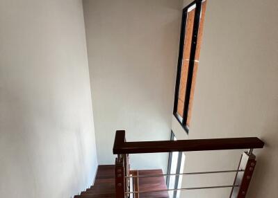 Modern staircase with wooden steps and metal railing