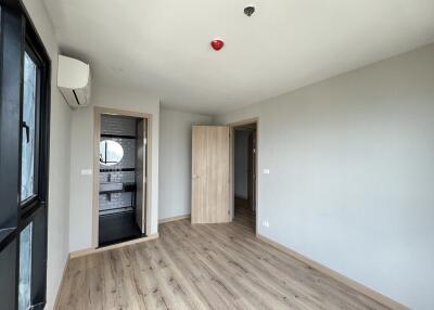 Bedroom with hardwood floors, open door to a bathroom, and large window