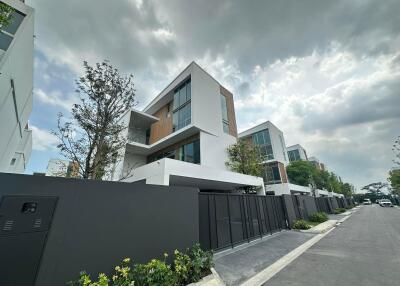 Modern multi-story residential building with angular design and large windows.