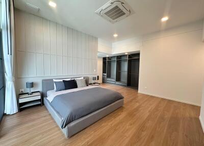 Modern bedroom with wooden flooring and large windows