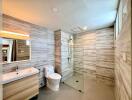 Modern bathroom with wooden paneling, glass shower, and contemporary fixtures