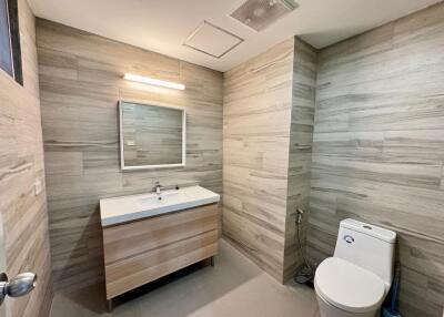 Modern bathroom with wood-like tile walls and vanity