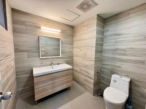 Modern bathroom with wood-like tile walls and vanity