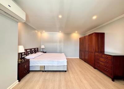 Spacious bedroom with wooden furniture and lighting