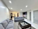 Modern living room with grey couches and glass coffee table