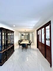 Elegant dining area with table setup and glass cabinet