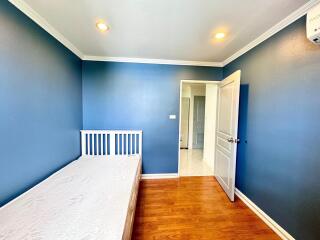 Small bedroom with white bed and blue walls