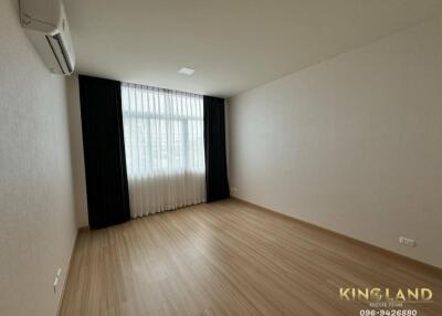 Empty bedroom with wooden floor and large window